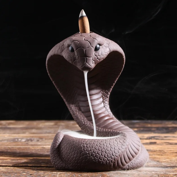 Cobra backflow incense burner with smoke flowing from mouth